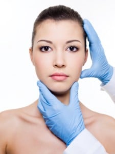 Face of a young woman getting checked with latex glove for Mini Facelift, Princeton, NJ