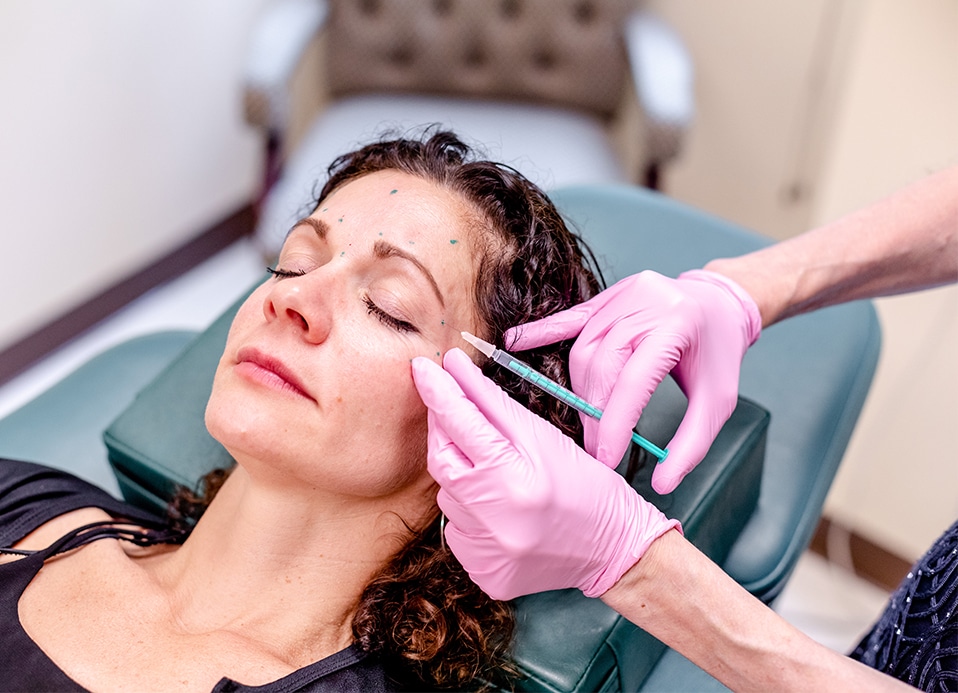 Woman getting a wrinkle treatment injection from Dr. Brunner