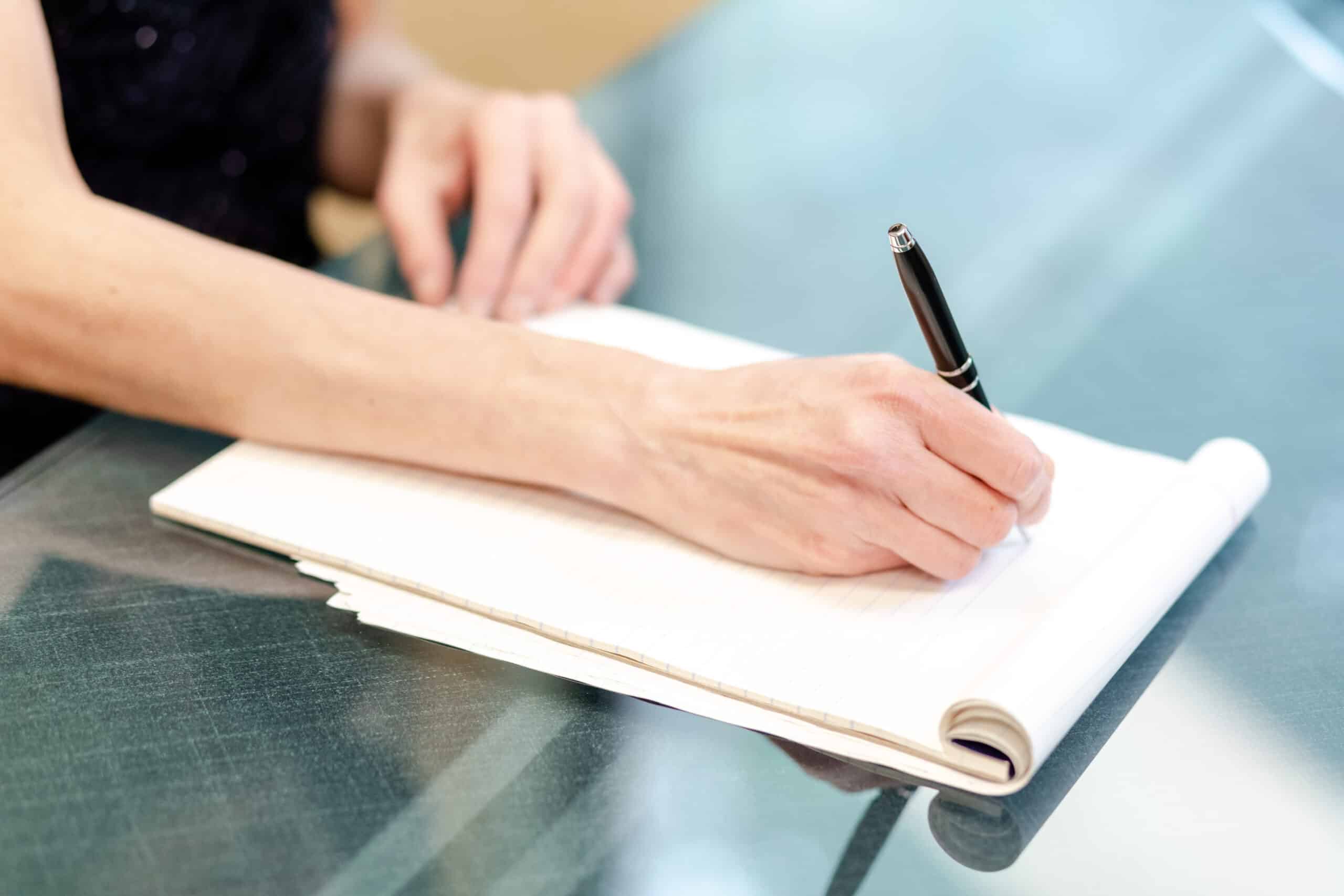 writing-on-paper Woman taking notes on a pad of paper