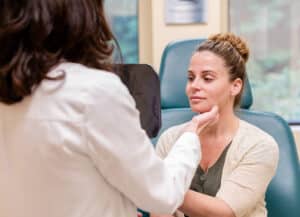 patient looking in the mirror at her cosmetic treatment results in Princeton, NJ